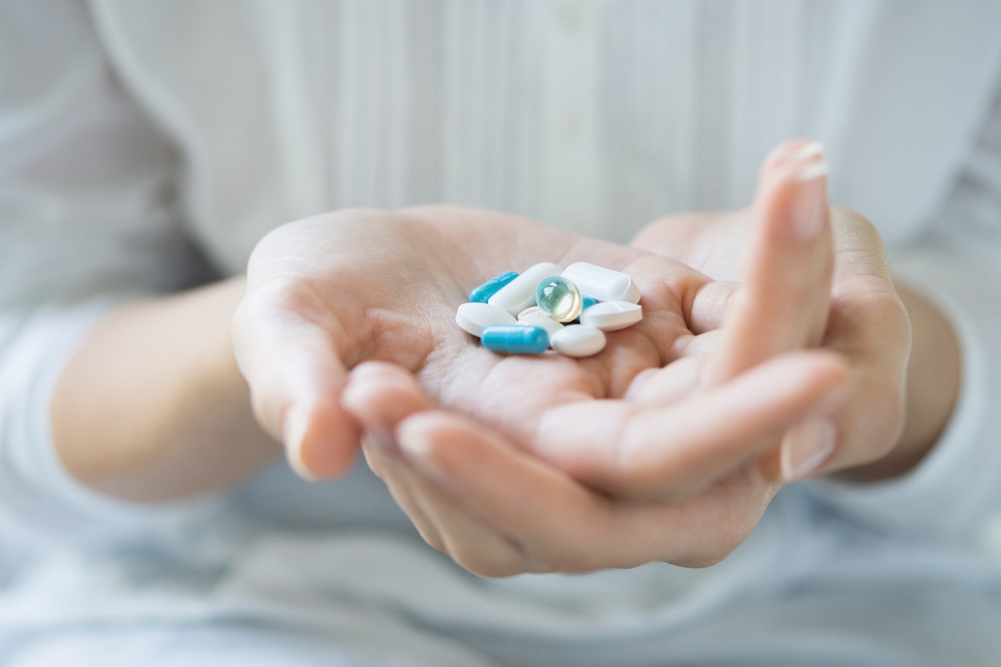 Frau, die mehrere Tabletten in der Hand hält