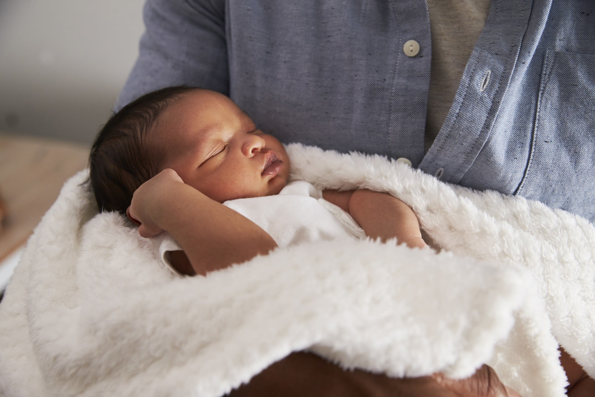 Neugeborenes Baby auf dem Arm schlafend