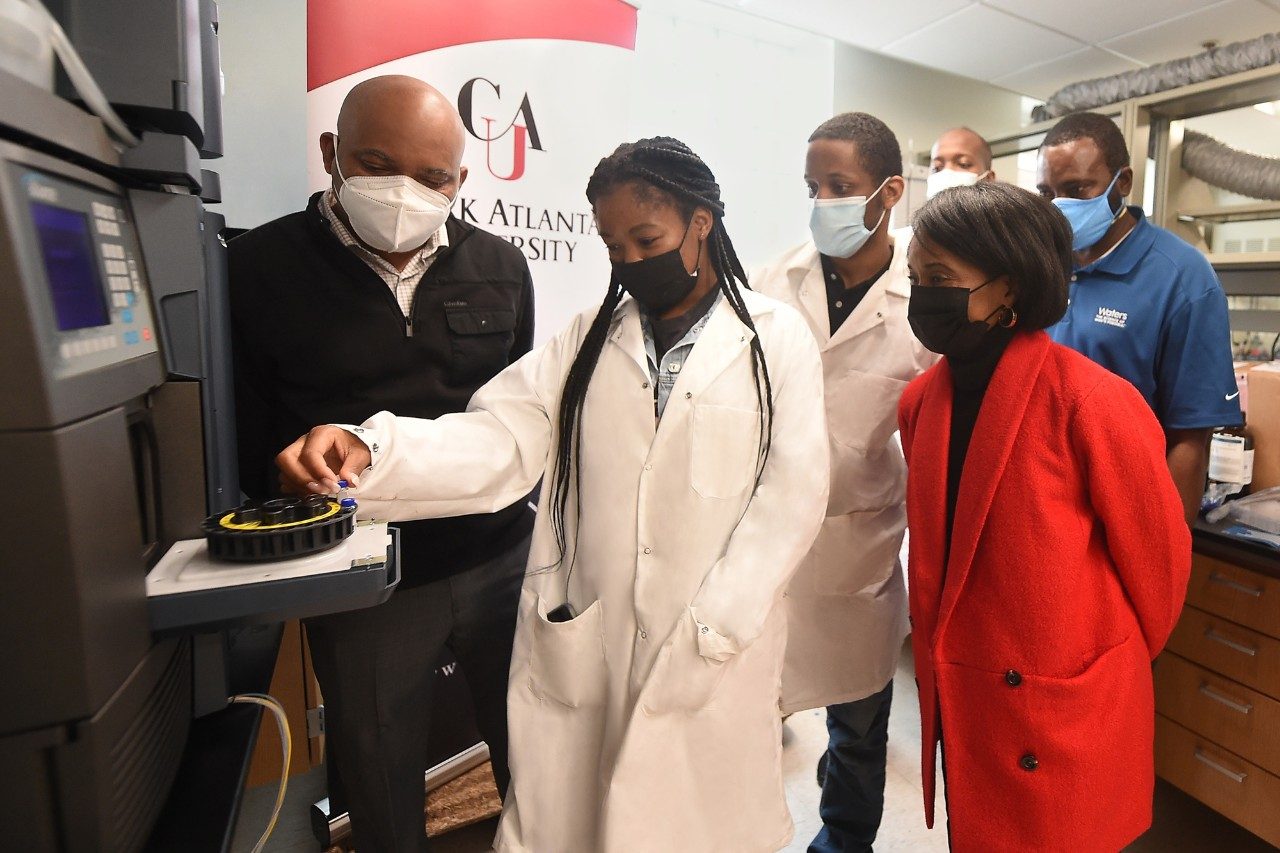 Clark Atlanta University professor guides graduate students in loading samples in the Waters Alliance HPLC