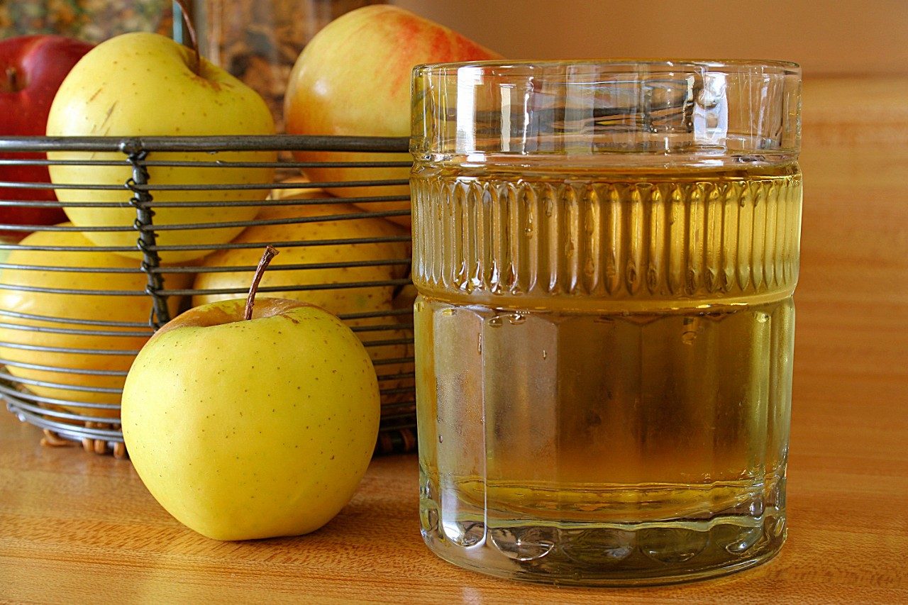 Apples in basket and glass of apple juice