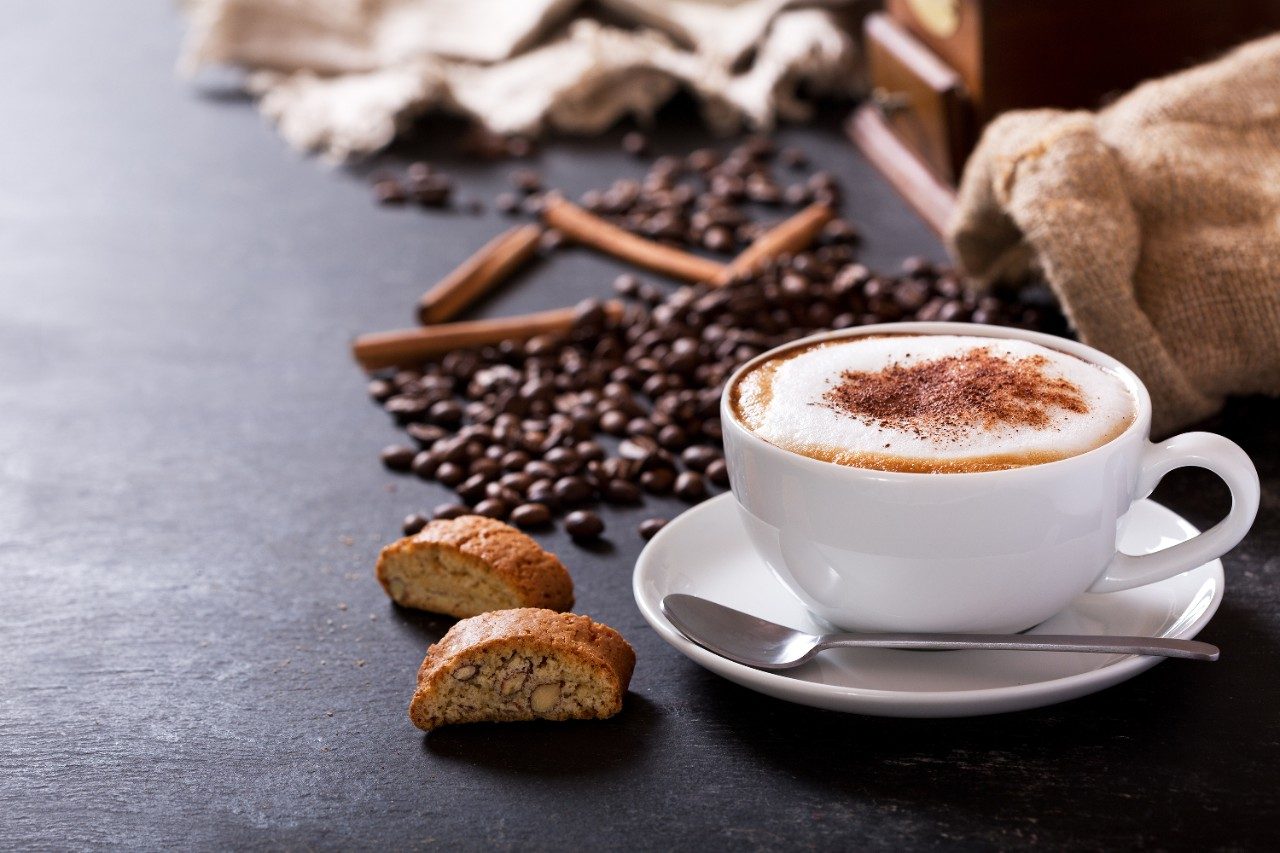 Cup of cappuccino coffee on dark table