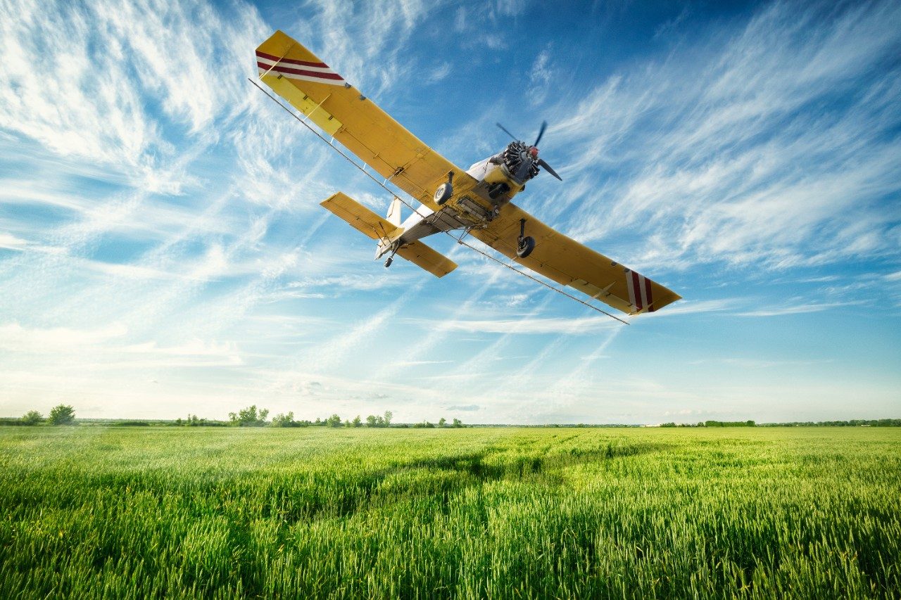 Crop dusting plane over field