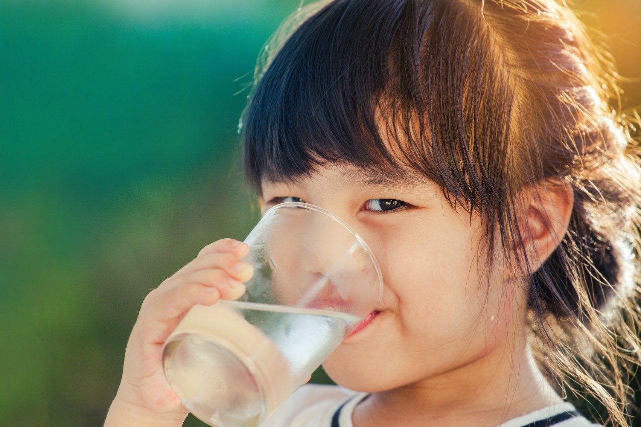 Girl holding glass of water smiling