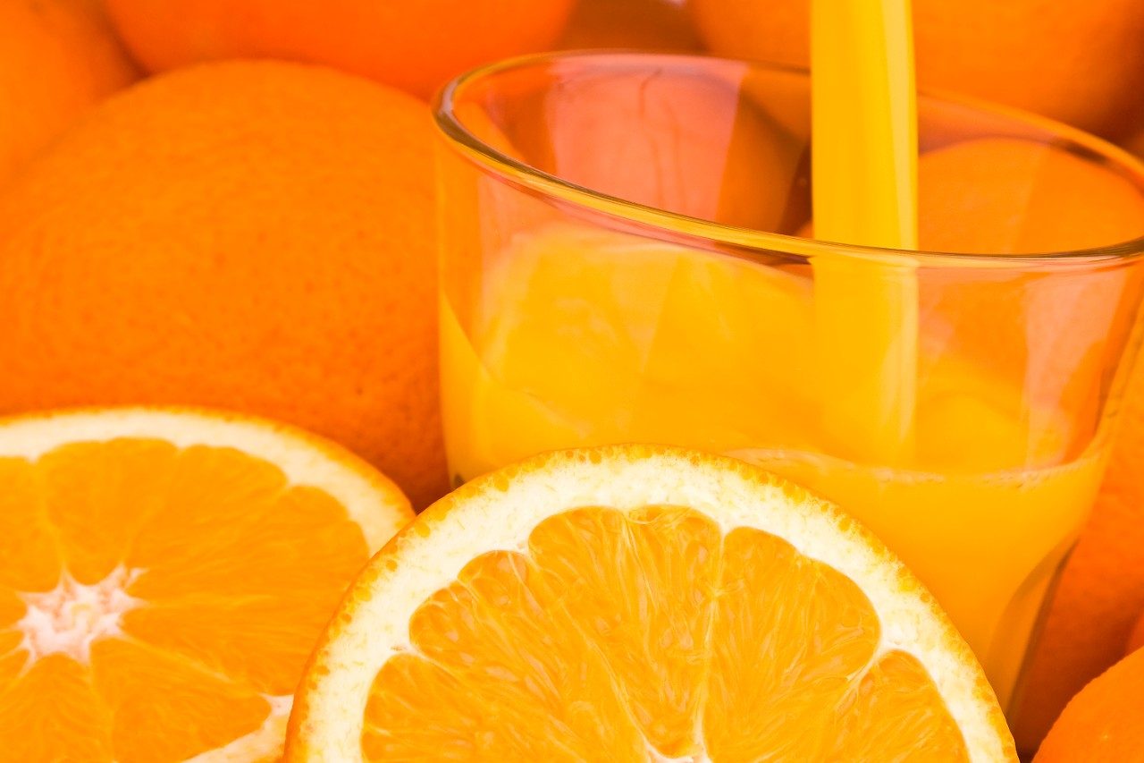 Orangensaft in ein Glas gießen