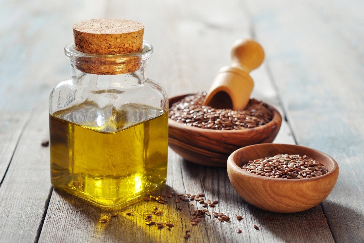 Sesame seeds and oil in bottle on table