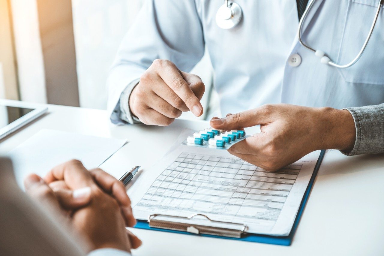 Doctor or physician recommending prescription pills to patient