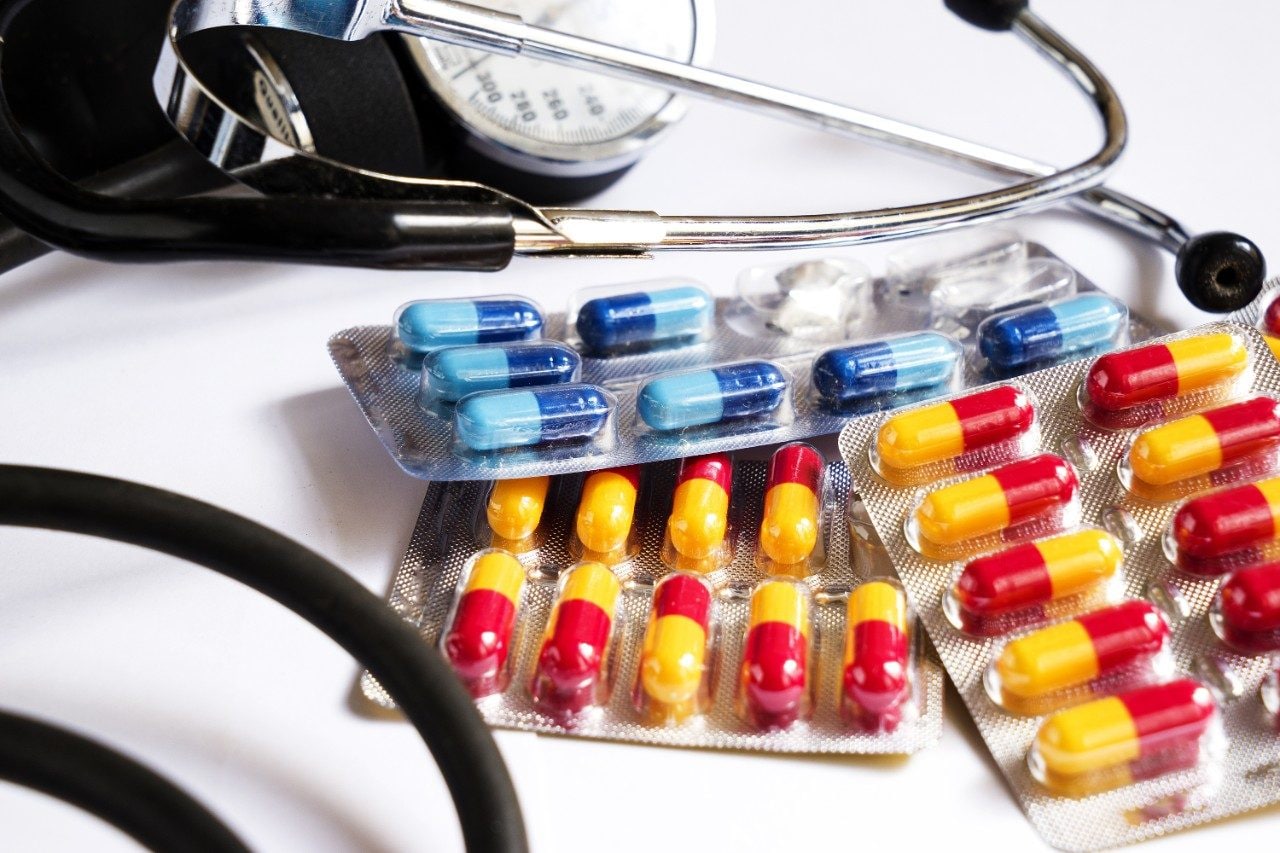 Blood pressure monitor and medicines in different colored capsules