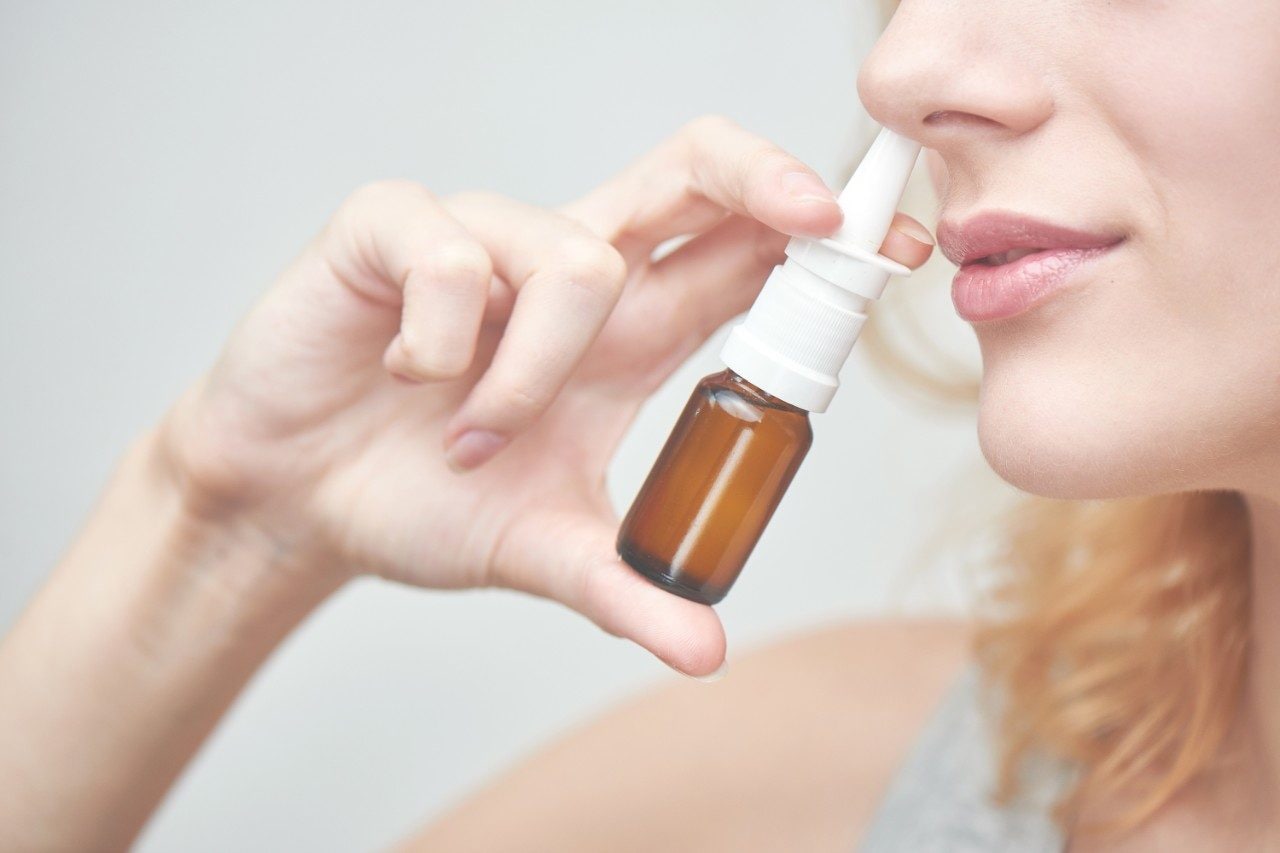 Woman using budesonide nasal spray