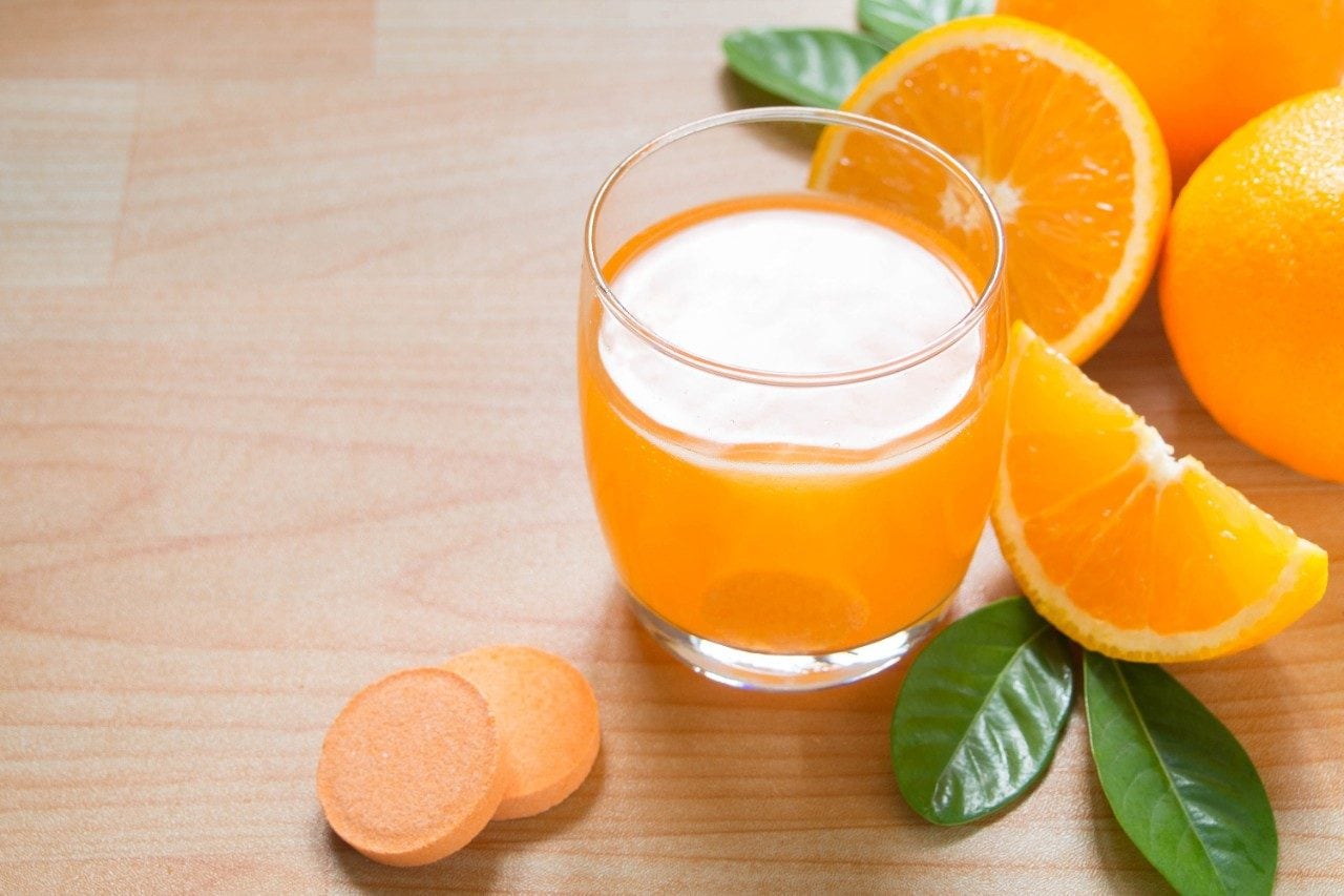 Vitamin c effervescent tablet is dissolving in glass of water