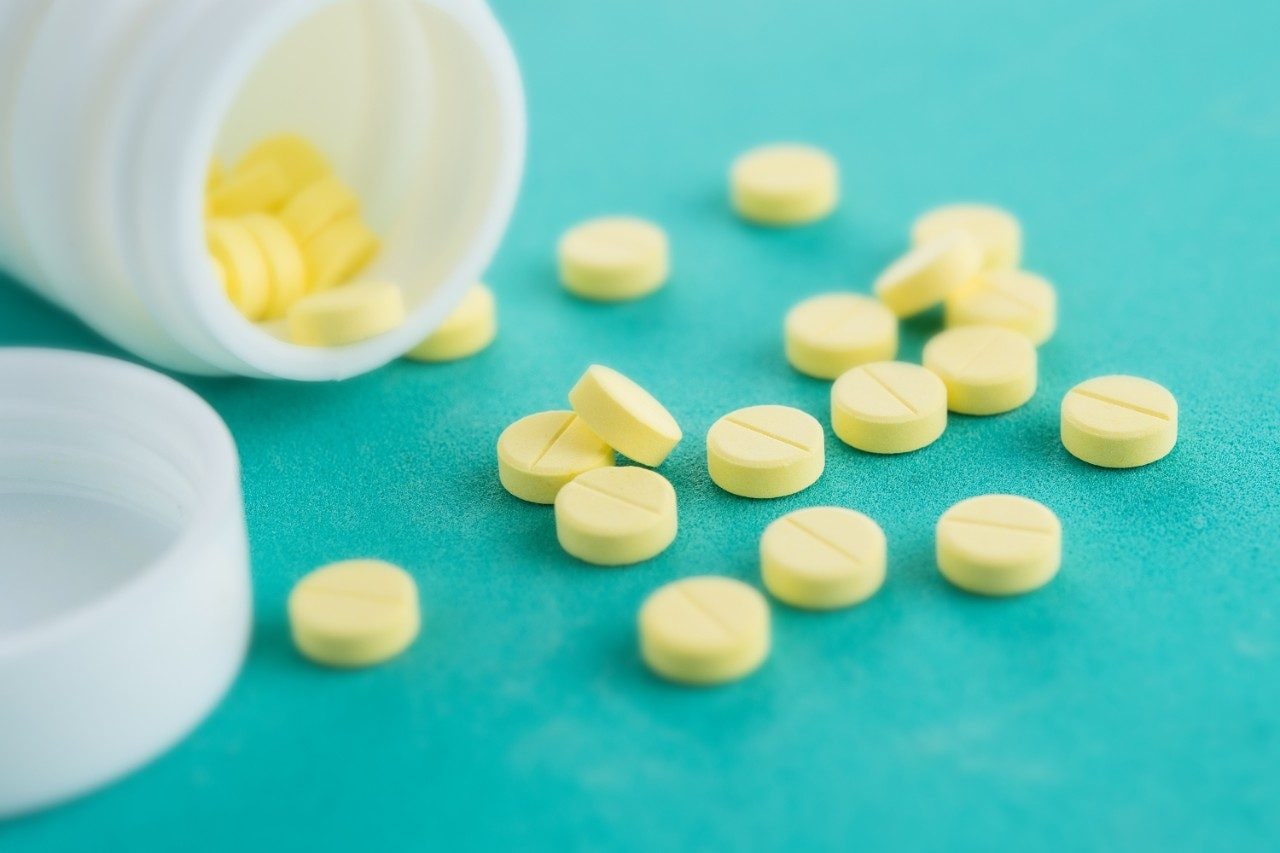 Yellow pills with bottle on green mint background, Healthy and Medicine concept