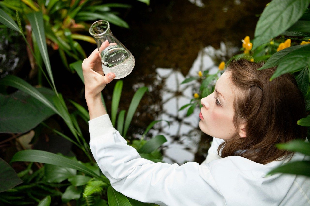 Female researcher inspecting beaker