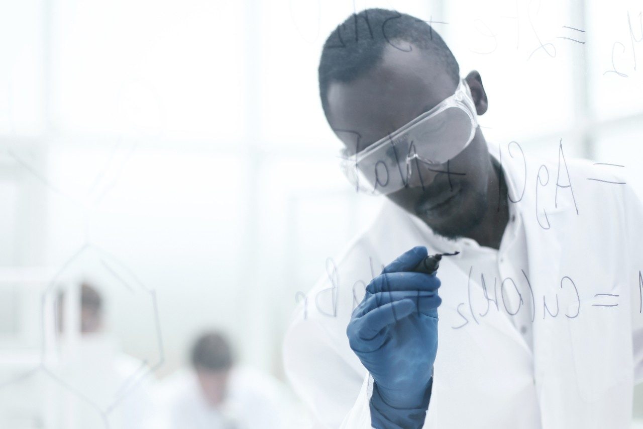 Scientist writing chemical formula on a glass Board.photo with copy space