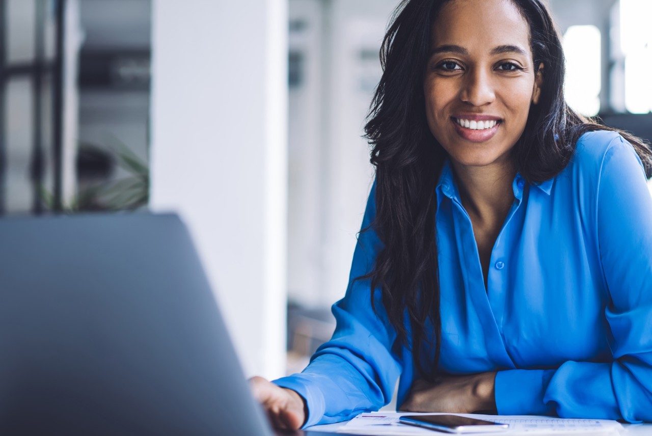 Smiling businesswoman using laptop at work