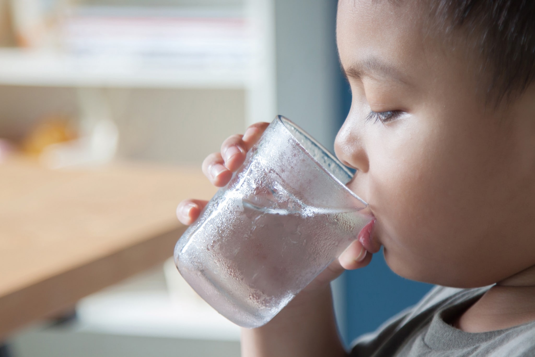 グラスから水を飲んでいる子供