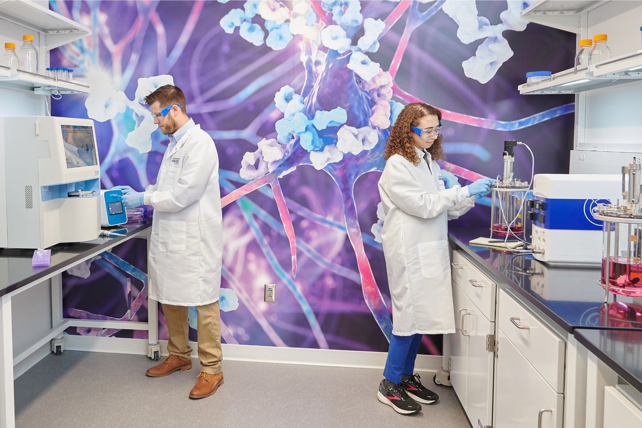 Dois cientistas no Laboratório Immerse Delaware com fundo científico roxo